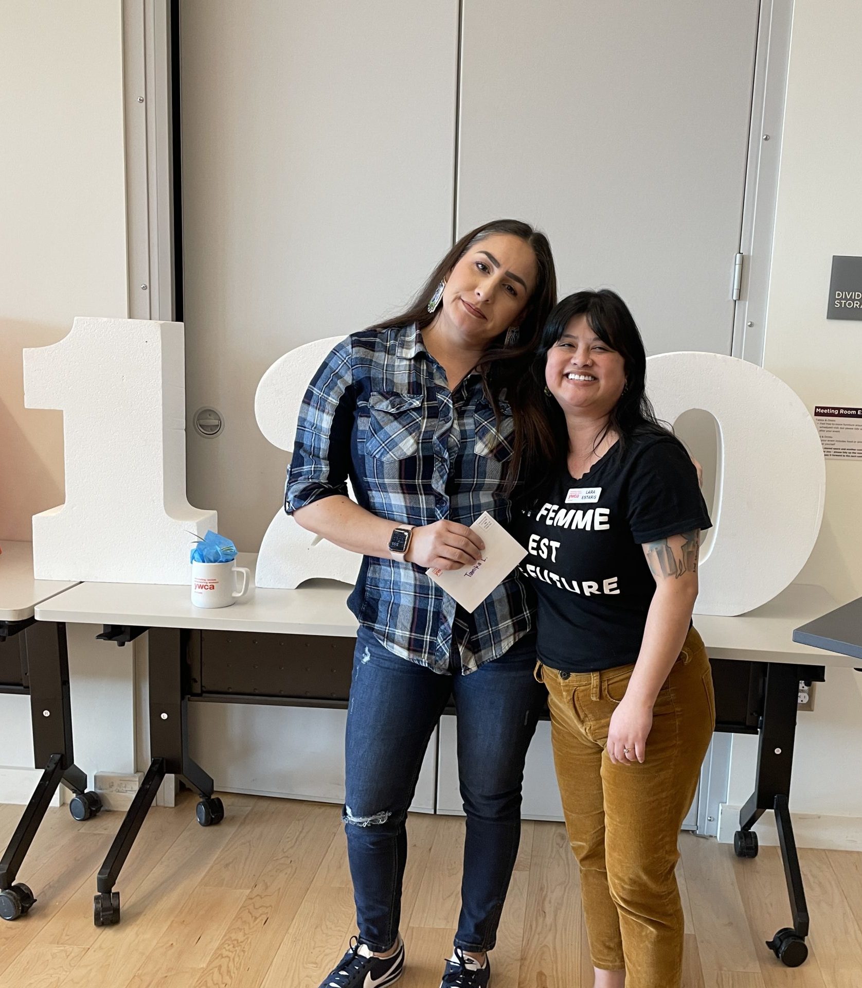 Photo of two smiling women, both with long dark hair and brown eyes.